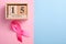 Pink ribbon and wooden cube calendar set for October 15 on a pink and blue background. Breast Cancer Awareness Month