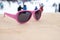 Pink-rimmed sunglasses on wooden slope in aprÃ¨s ski bar or cafe, with ski slope in background, copy space. Concept of winter