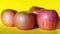 Pink ripe apples on a yellow backdrop