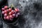 Pink ripe grapes in a colander. Black background. Top view. Copy space