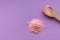 Pink rose bath salt with wooden spoon on lilac background with copy space. Aroma spa concept. Aromatherapy .