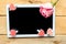 Pink rose and decorative hearts on the mockup tablet. Valentine`s Day, Wedding or Mother`s Day greeting card.