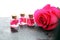 Pink rose flower and glass of bottle essential oil. spa and aromatherapy cosmetic concept