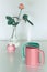 Pink rose flower and twin half tea mugs in salmon pink and fresh mint green. Minimalist design for your house in pastel colors.