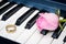 Pink rose and golden ring on the piano keyboard