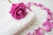 Pink rose and petals on white towel