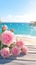 Pink roses grace wooden table against backdrop of romantic beach