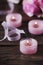 Pink roses and pinl candles on the wooden table