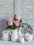 Pink roses in a white enameled pitcher, vintage crockery on blue wooden rustic background. Kitchen still life in vintage style
