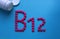 Pink round pills lined with the letter B12