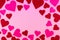 Pink Saint Valentine`s day background with red and pink hearts, copy space at the center