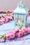 Pink sakura flowers and decorative lantern with candle on blue