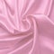 Pink satin fabric texture, silk background with folds. Wavy abstract pattern, luxury shiny bed sheet, soft textile. Flow effect.