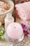 Pink scented candle, soft towels and bowl of sea salt
