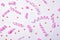 Pink serpentine streamers and heart shaped confetti on white background, top view