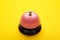 Pink service bell on a yellow background