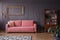 Pink settee against grey wall with mockup of gold frame in elegant living room interior. Real photo