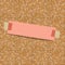 Pink sheet of paper for notes taped to a corkboard