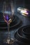 Pink shimmering champagne glass and black stoneware on a rustic black table