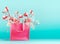 Pink shopping bag with spring blossom branches standing at turquoise blue background. Trendy color. Creative spring time and
