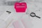 Pink shopping basket on marble desk with shopping list notebook magnifying glass and calculator