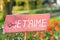 Pink sign in a field of flowers, tulips, saying  `I love you` in French