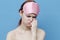 pink sleep mask and energetic woman emotions blue background