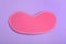 Pink sleeping mask on violet background, top view. Bedtime accessory