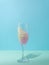 Pink slime in champagne glass. Conceptual setting pastel blue. Spring shades