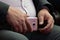 Pink smartphone in the hands of a fat man in a suit and white shirt. Close-up. An official, deputy, businessman or boss. Modern