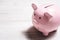 A Pink Smiling Piggybank On A Table