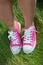 Pink sneakers on girl legs on grass