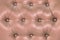 Pink soft leatherette background with symmetrical buttons. Soft and expensive furniture elements. Luxury background