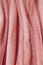 Pink soft tulle polka dot or tulle with flies, texture background. Lined tulle dress for girl, fabric folds or waves. Selective