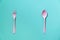 Pink spoon and fork on green table background, food and healthy concept