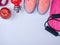 Pink sports sneakers and a red water bottle, black jump rope