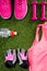 Pink sportswear, accessories and shoes, for fitness, a bottle of water, on the background of grass