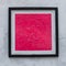 Pink square in frame hanging on the white wall. Modern art