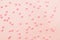 Pink star shaped sprinkles on light pink background. Colourful edible cake decoration on pink background