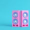 Pink stereo speakers on bright blue background in pastel colors