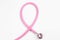 Pink stethoscope on white, top view. Breast cancer awareness
