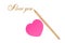 Pink sticker in the form of heart and a gold pencil on the white