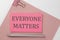 Pink sticker on pink paper with pencil on a white background with text EVERYONE MATTERS