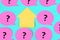 Pink stickers with questions written on them. In the center there is an empty yellow sticky piece in the form of a house