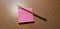 Pink sticky notes and a wooden graphite pencil on a wooden office table