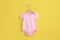 Pink Striped Baby Bodysuit on Yellow Background