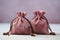 Pink suede fabric bags with laces, decorated with stones and amulets for jewelry