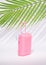 pink suitcase with blue sunglasses on a summer day in the shade of tropical green palm