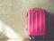 Pink suitcases on brick wall background