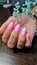 Pink summer gel polish manicure with unicorn picture